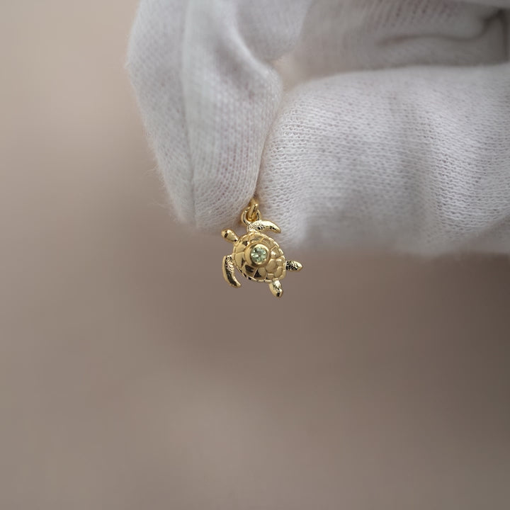 Goldschildkröten-Anhänger mit grünem Edelstein Peridot. Niedlicher Schildkröten-Anhänger mit grünem Kristall-Peridot, auch der Geburtsstein des Monats August.