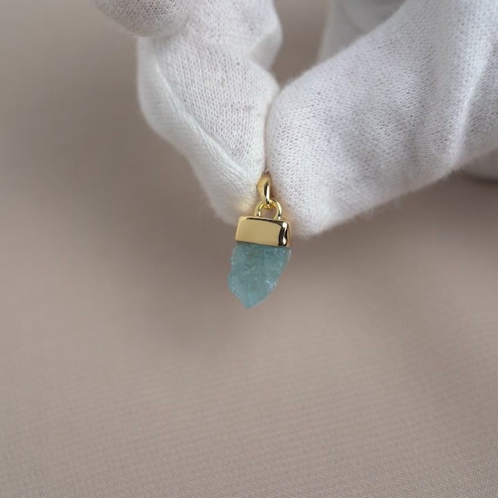 Rohblauer Aquamarin-Kristallanhänger. Ein blauer roher Edelsteinanhänger mit Aquamarin in Gold.