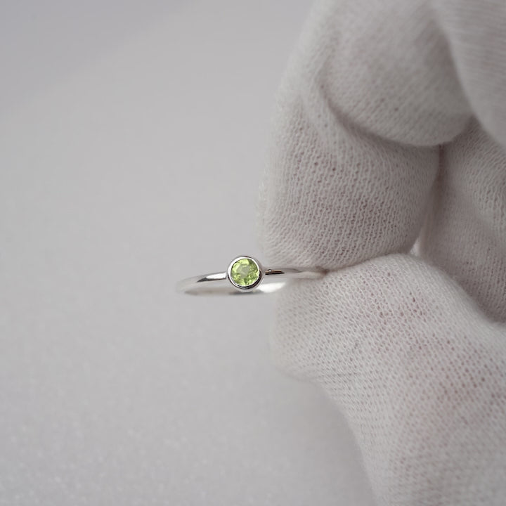 Silberring mit Peridot, dem Geburtsstein des Monats August. Edelsteinring in modernem und zierlichem Design mit grünem Kristall-Peridot.