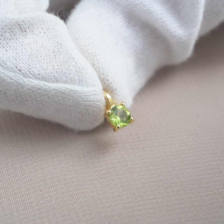 Kristallanhänger mit grünem Edelstein Peridot mit goldenen Details. Gold-Edelstein-Charm mit Peridot in Gold.