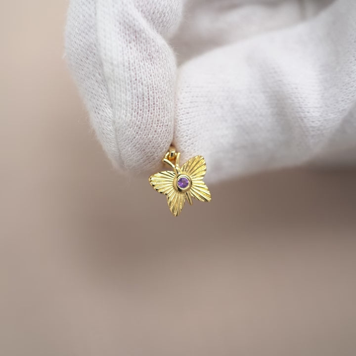 Edelsteinanhänger mit violettem Kristall-Amethyst in einem goldenen Schmetterling. Amethystschmuck mit einem Schmetterling in Gold.