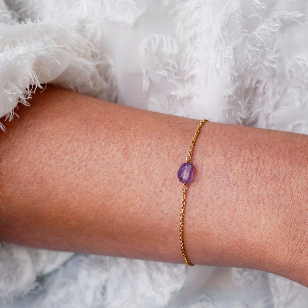 Goldarmband mit einem kleinen violetten Rohkristall. Armband mit kleinem rohen Amethyst-Edelstein in Gold.