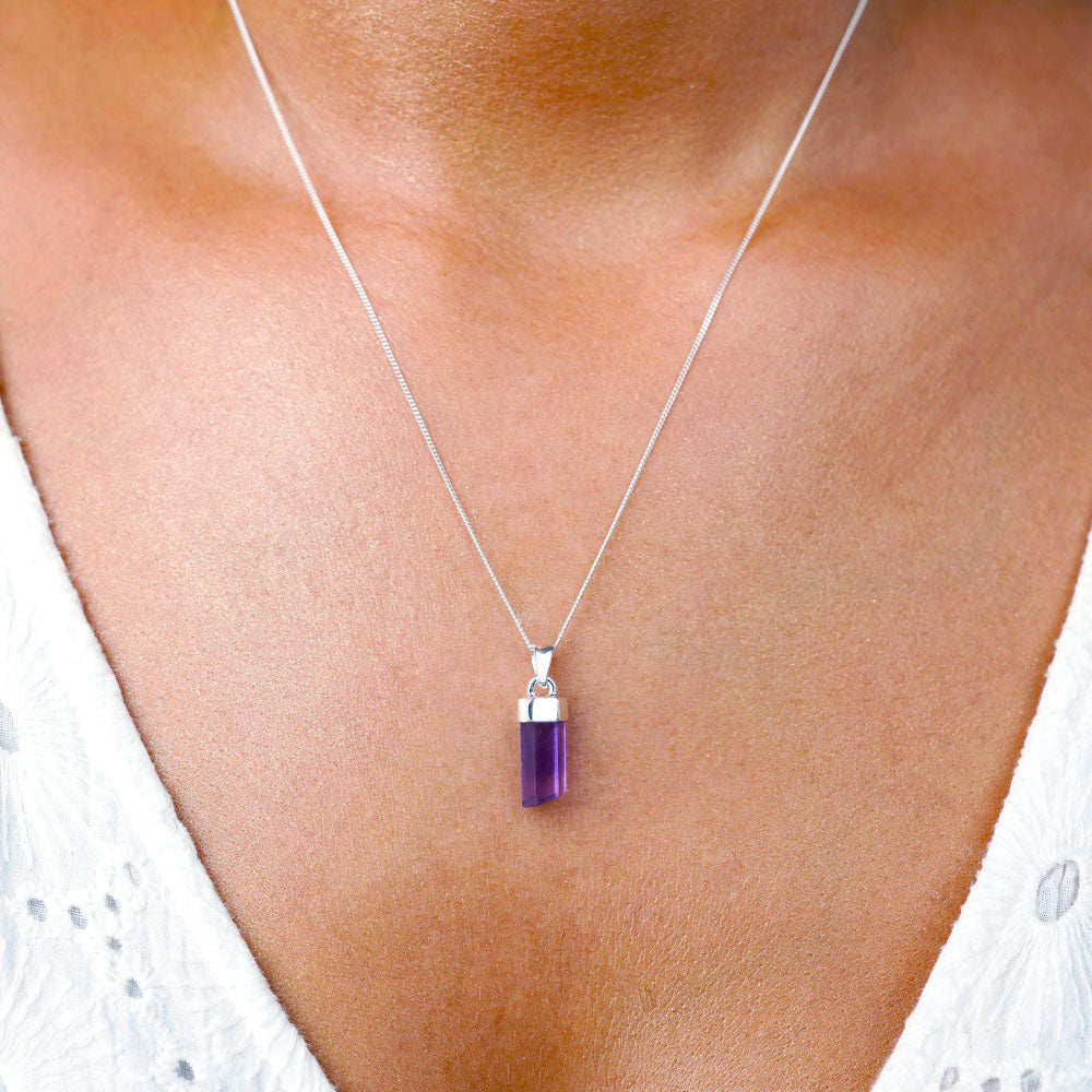 Halskette mit Amethystspitze, dem Geburtsstein des Monats Februar. Schmuck mit einer Amethystspitze, der als Halskette getragen wird und als Schutz dient.