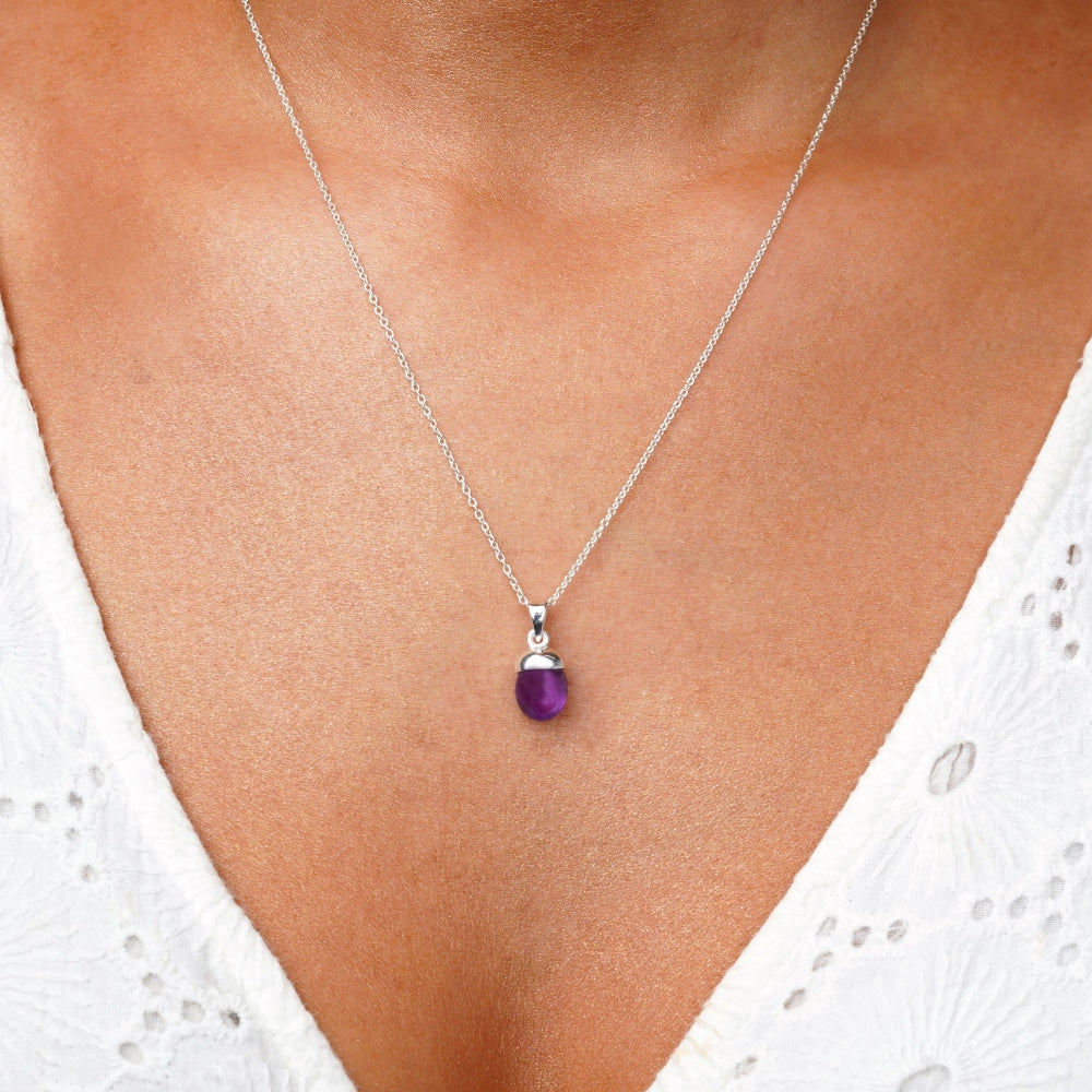 Silberne Halskette mit lila Amethyst in modernem Design. Wunderschöner Anhänger mit Amethyst, der in einem wunderschönen hellvioletten Farbton auf der Haut leuchtet.